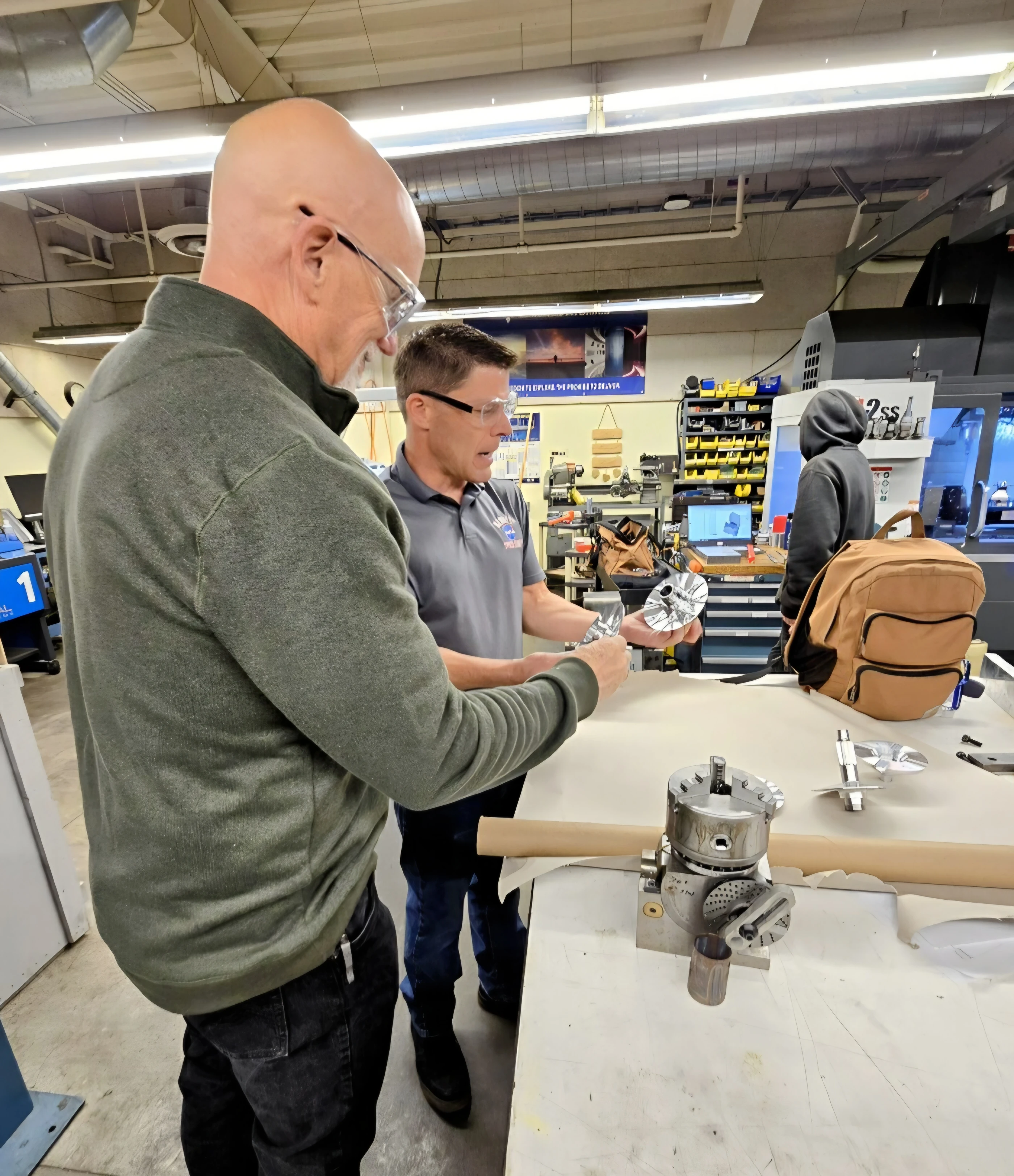 Tim Engel being shown CNC machined parts during a manufacturing shop floor tour